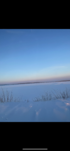 Frozen lake with snowy landscape and clear blue sky in Finnish Lapland